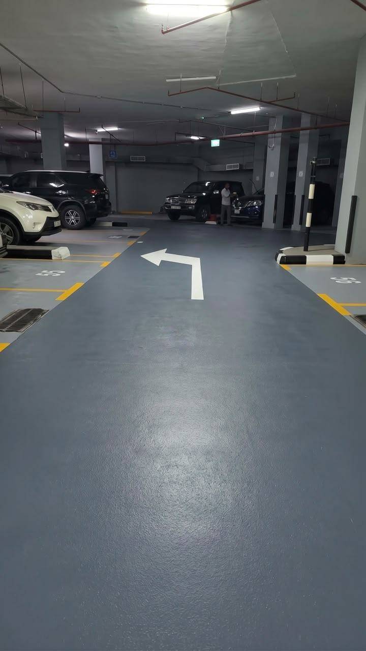 Car park epoxy flooring with aggregate — lanes and direction arrows — DIB Bank Building, Sharjah