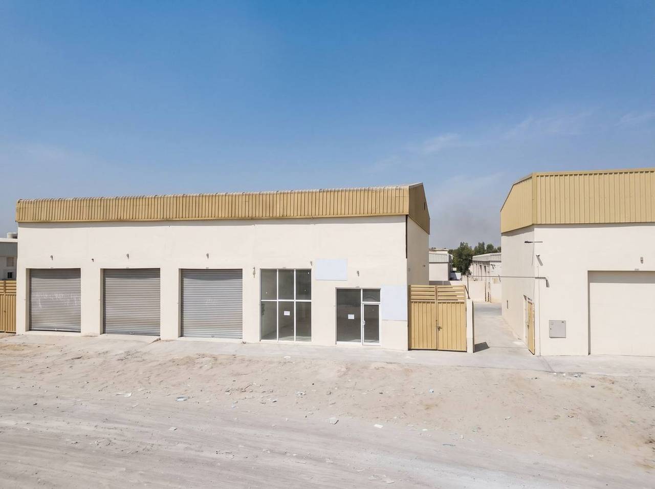 Warehouse block — roller-shutter units and service yard — Al Sajaa Industrial, Sharjah